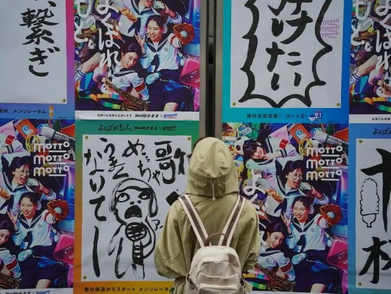 someone wearing grey jacket looking at wall full of japanese shows posters